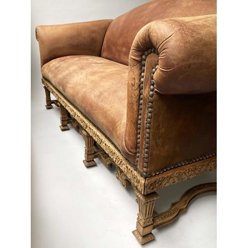 233 - SOFA, early 20th century, natural hide leather, brass studded, with arched back scroll arms and carv... 