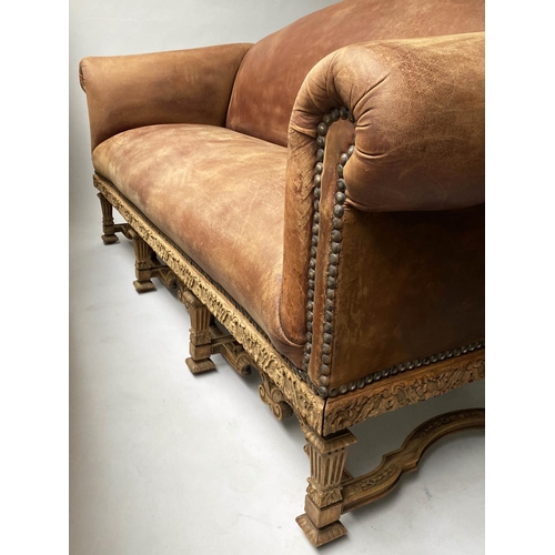 233 - SOFA, early 20th century, natural hide leather, brass studded, with arched back scroll arms and carv... 