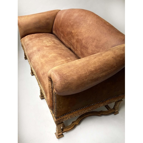 233 - SOFA, early 20th century, natural hide leather, brass studded, with arched back scroll arms and carv... 