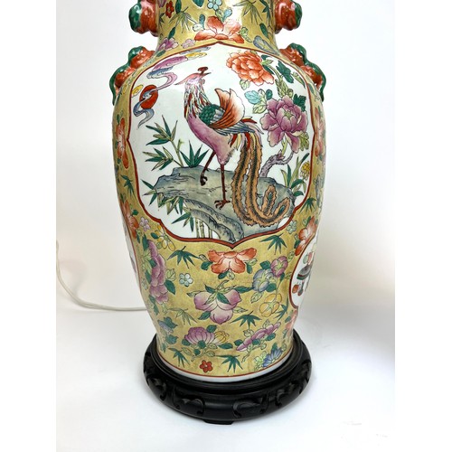 296 - CHINESE VASE LAMPS, a pair, Chinese hand painted ceramic with carved hardwood bases, 61cm H. (2)