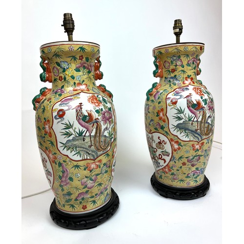 296 - CHINESE VASE LAMPS, a pair, Chinese hand painted ceramic with carved hardwood bases, 61cm H. (2)