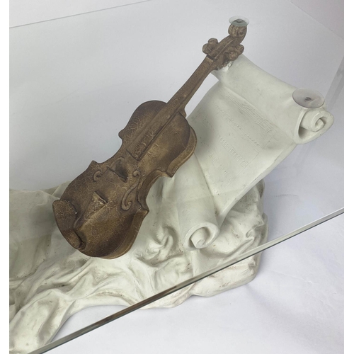 406 - LOW TABLE, 107cm W, of violin and scrolling sheet music form base and rectangular glass top.