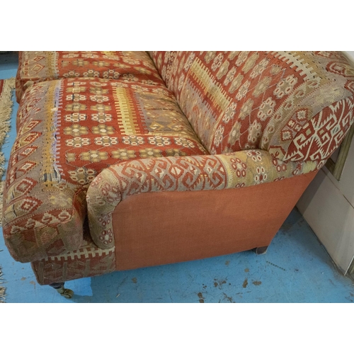256 - KILIM SOFA, 186cm x 94cm, three seater with turned feet and brass castors.