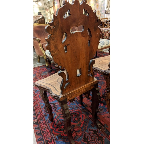 287 - HALL CHAIRS, a set of four, 19th century Swiss walnut with carved backs and marquetry detail. (4)