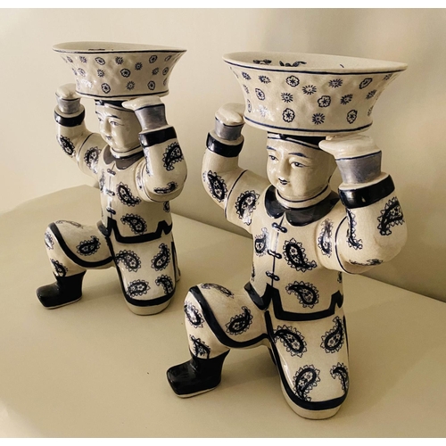 557 - TRINKET DISHES, a pair, 33cm x 23cm x 18cm, in the form of Chinese men holding baskets. (2)