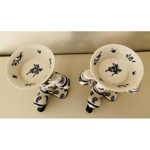 557 - TRINKET DISHES, a pair, 33cm x 23cm x 18cm, in the form of Chinese men holding baskets. (2)