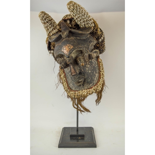 116 - KUBA MASK, Congolese, ornately carved wood, adorned with Cowrie shells and grass fiber 90cm H