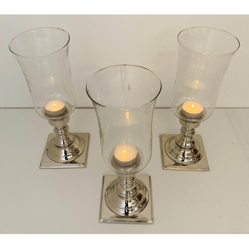 594 - STORM LANTERNS, a set of three, chrome plated bases, 41cm x 15cm.