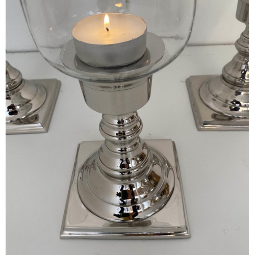 594 - STORM LANTERNS, a set of three, chrome plated bases, 41cm x 15cm.