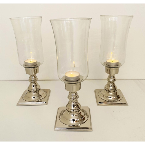 594 - STORM LANTERNS, a set of three, chrome plated bases, 41cm x 15cm.