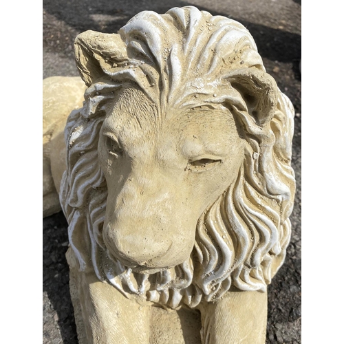 596 - RECUMBENT LIONS, a pair, composite stone, 35cm H x 60cm x 35cm. (2)