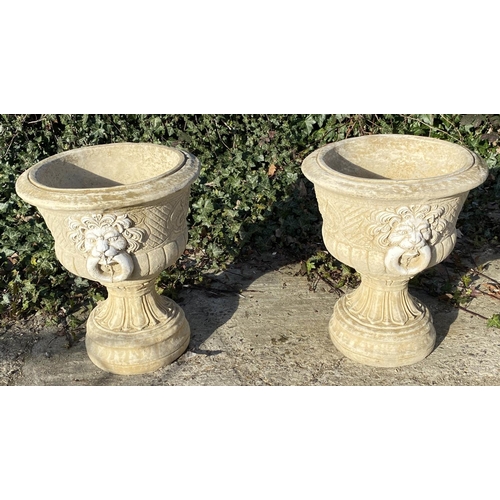 634 - GARDEN PEDESTAL URNS, a pair, Regency style, composite stone, twin handled with cast decoration, 67c... 