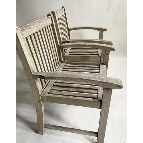 159 - GARDEN ARMCHAIRS, a pair, nicely weathered slatted teak with curved arms and a low X frame table by ... 