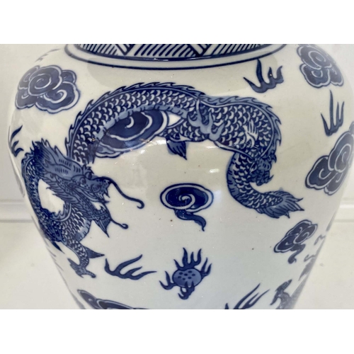 480 - CHINESE DRAGON URNS AND COVERS, 38cm x 22cm, blue and white under glaze decoration, with stands. (2)