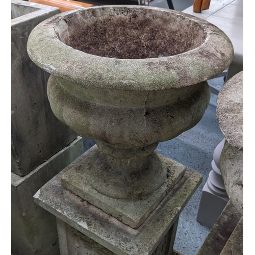 362 - ARCHITECTURAL GARDEN URNS, on stands, a set of two, composite stone, grape detail on one pedestal ro... 