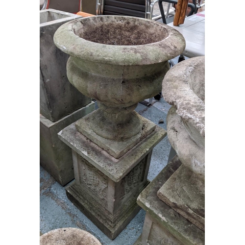 362 - ARCHITECTURAL GARDEN URNS, on stands, a set of two, composite stone, grape detail on one pedestal ro... 