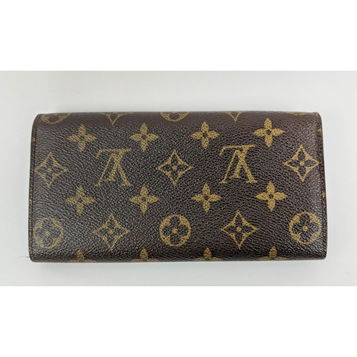 26 - LOUIS VUITTON MONOGRAM WALLET, with a central zipped coin pocket, multiple card slots, two large com... 