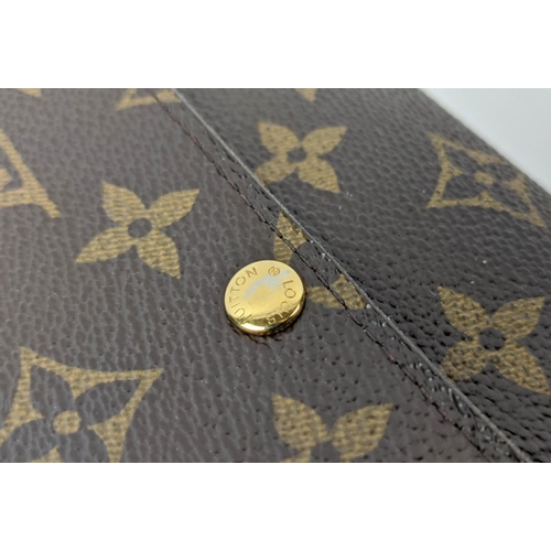 26 - LOUIS VUITTON MONOGRAM WALLET, with a central zipped coin pocket, multiple card slots, two large com... 