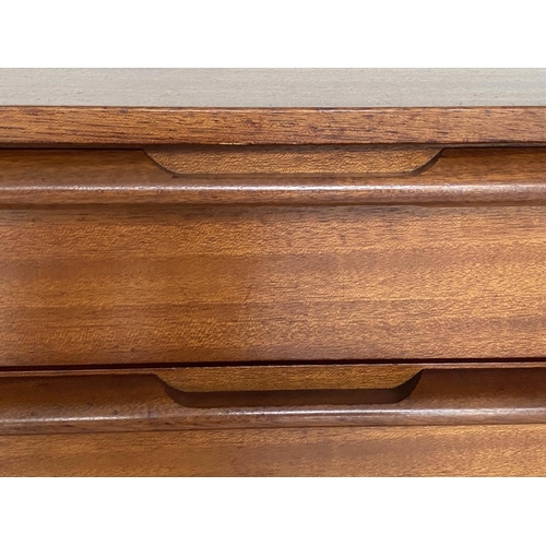 373 - CHEST, 1960's Afromosia teak, with three long drawers, integral handles and shaped tapering supports... 