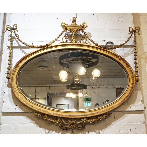 346 - WALL MIRROR, 89cm H x 107cm W, Victorian giltwood,  with oval bevellled plate and urn crest.