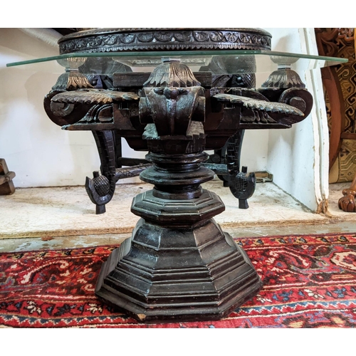 266 - LOW TABLE, Indian ebonised with revolving support and hexagonal glass top, 61cm x 61cm x 48cm H.