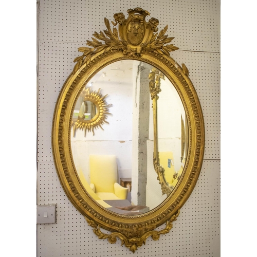 WALL MIRROR, circa 1880, French giltwood and gesso with old oval bevelled plate and cartouche surmount, 121cm H x 80cm.