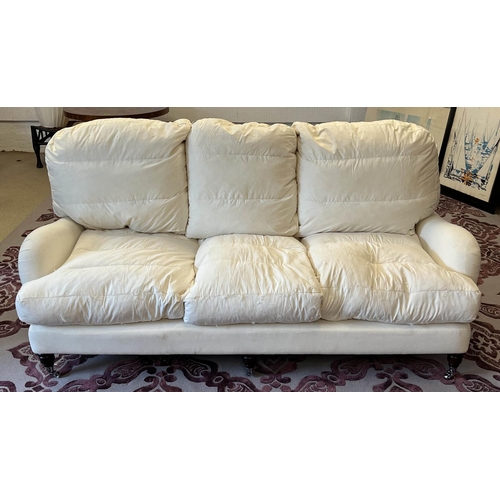 165 - HOWARD STYLE SOFA, three seater, feather filled with turned front supports and castors, 198cm W.