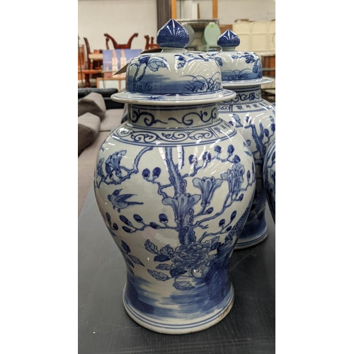 330 - TEMPLE JARS, a set of three, Chinese export style, blue and white ceramic, cherry blossom decoration... 