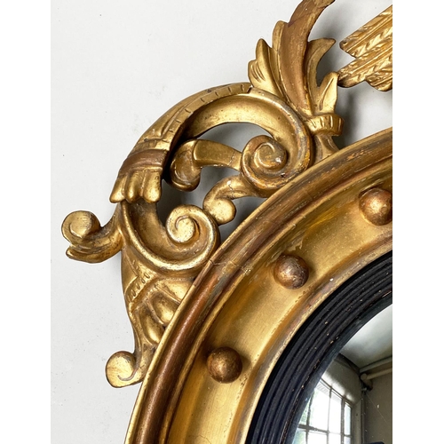 313 - CONVEX WALL MIRROR, 19th century, giltwood circular frame with eagle crest and reeded ebonised slip,... 