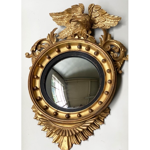 313 - CONVEX WALL MIRROR, 19th century, giltwood circular frame with eagle crest and reeded ebonised slip,... 