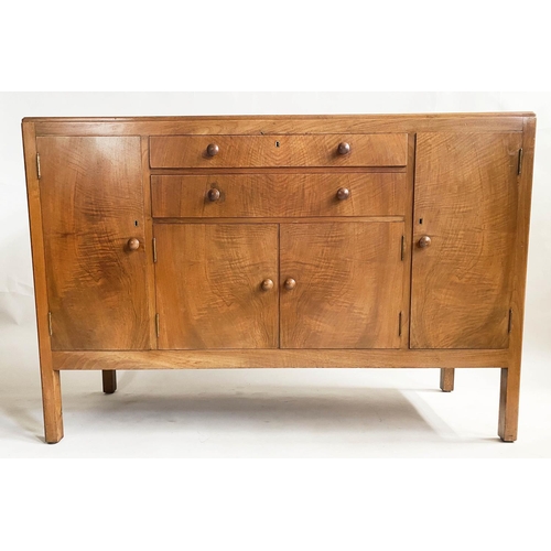 504 - HEALS SIDEBOARD, 1950s figured walnut, with drawers and cupboards flanked by further cupboards, labe... 