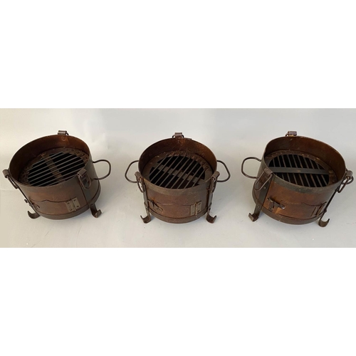 510 - SMALL FIRE PITS, each of two handled form, raised on three feet, 22cm x 36cm x 25cm. (3)