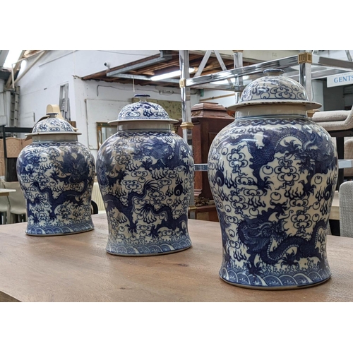 318 - TEMPLE JARS, a set of three Chinese export style, blue and white ceramic, dragon decoration, 44cm at... 