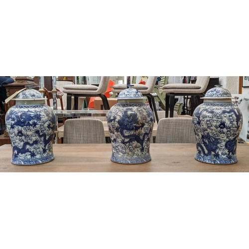 318 - TEMPLE JARS, a set of three Chinese export style, blue and white ceramic, dragon decoration, 44cm at... 