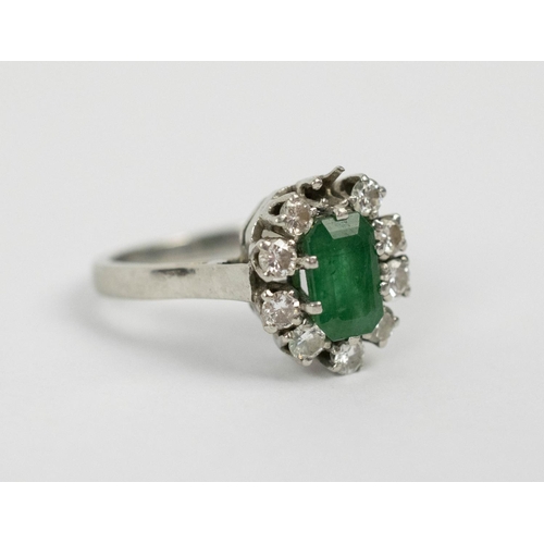 10 - AN EMERALD AND DIAMOND LADIES DRESS RING, white metal, the central emerald stone of approximately 1c... 