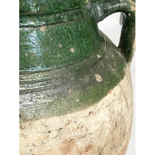 103 - OLIVE JARS, two Mediterranean terracotta of typical form, one with green glaze, 65cm H x 53cm H. (2)