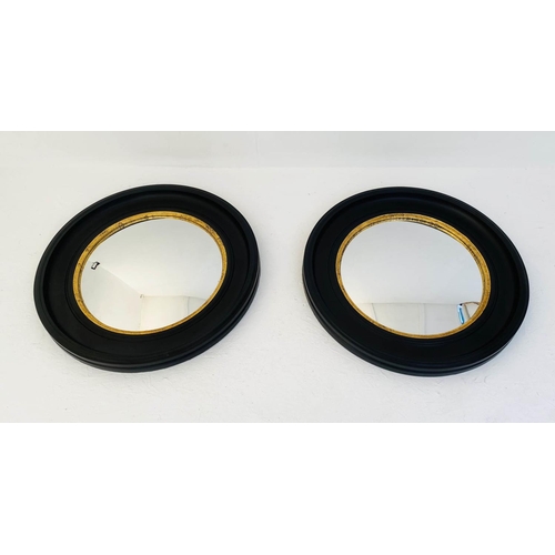 426 - CONVEX WALL MIRRORS, a pair, 74cm diameter, Regency style with black and gold circular frames. (2)