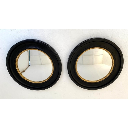 426 - CONVEX WALL MIRRORS, a pair, 74cm diameter, Regency style with black and gold circular frames. (2)