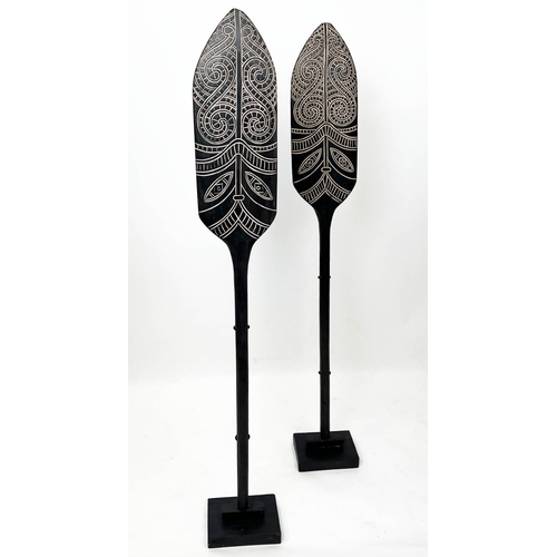 15 - MAORI STYLE PADDLES, a pair, on ebonised stands, 143cm H. (2)