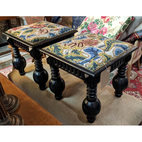 128 - STOOLS, a pair, each 42cm W x 42cm D x 42cm H with embroidered seats on carved ebonised bases. (2)