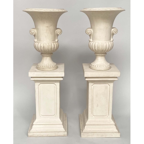 171 - URNS ON STANDS, a pair, campana form stone effect on plinths, 46cm W x 135cm H.