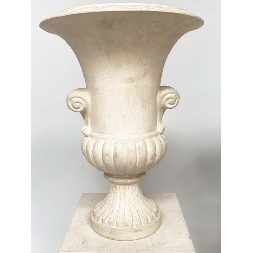 171 - URNS ON STANDS, a pair, campana form stone effect on plinths, 46cm W x 135cm H.