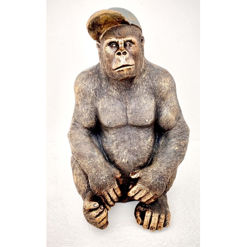 373 - GORILLA WEARING CAP, 58cm high, 40cm wide, 34cm deep, faux bronze finished resin.