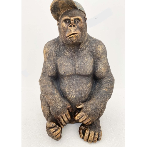 373 - GORILLA WEARING CAP, 58cm high, 40cm wide, 34cm deep, faux bronze finished resin.