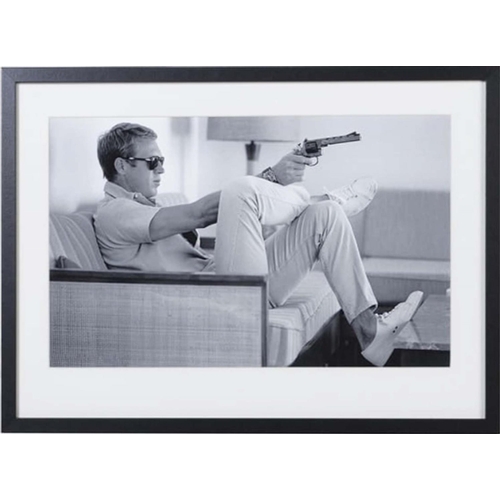 374 - AFTER JOHN DOWNING, Steve McQueen with gun, 54cm x 74cm, framed and glazed.