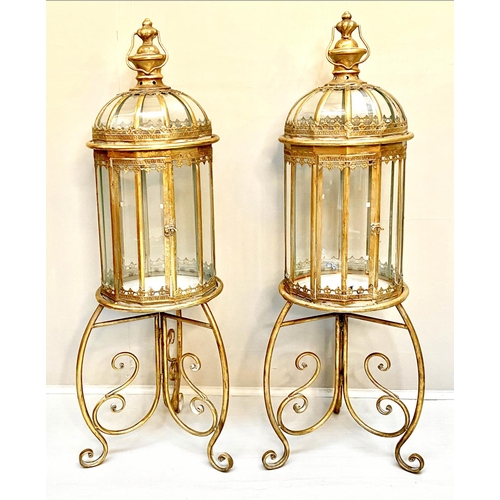 388 - STORM LANTERNS ON STANDS, gilt metal, Regency style, 115cm x34cm x34cm.