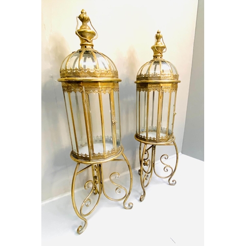 388 - STORM LANTERNS ON STANDS, gilt metal, Regency style, 115cm x34cm x34cm.