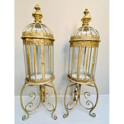 388 - STORM LANTERNS ON STANDS, gilt metal, Regency style, 115cm x34cm x34cm.