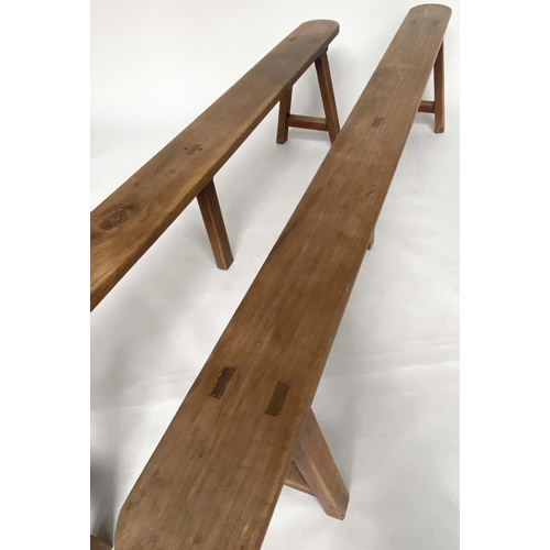 191 - BENCHES, a pair, 19th century French cherry wood rectangular with trestle supports, 231cm W. (2)