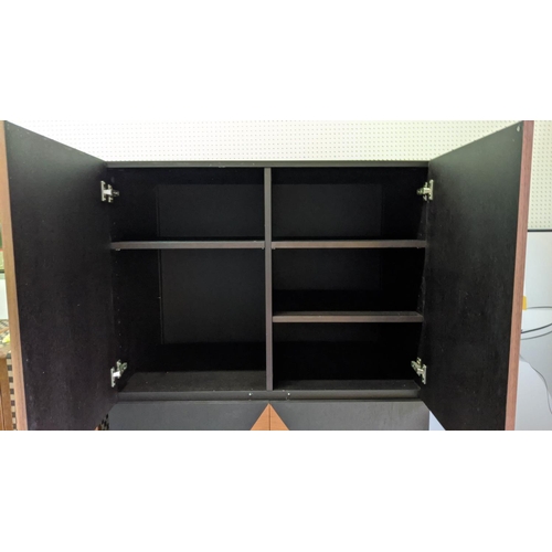 431 - CABINET, teak and ebonised book matched veneers, four doors enclosing adjustable shelves, chrome fee... 